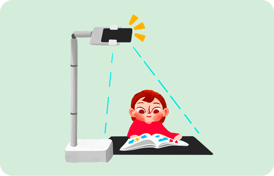 A child reads an open picture book under a phone held on a stand